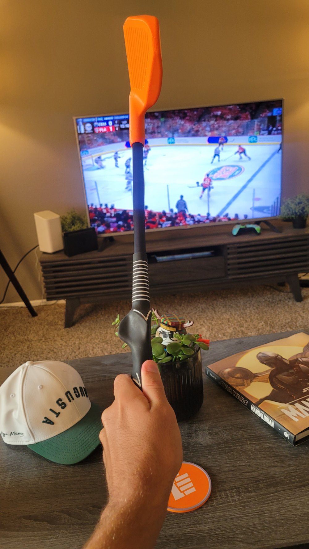 A Catalyst Compact Club in hand on the couch with hockey on TV